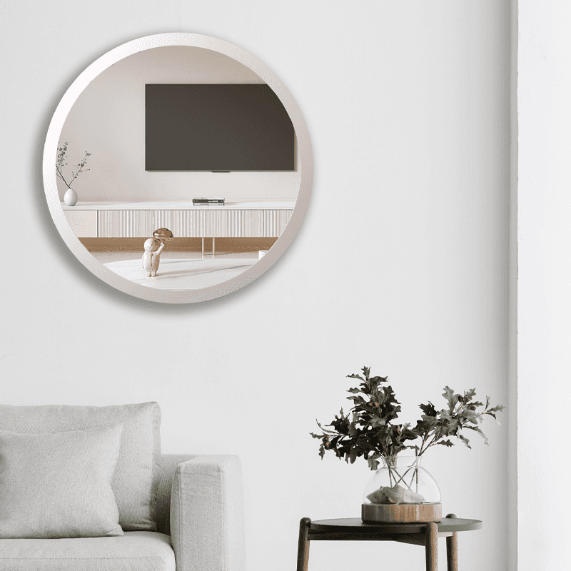 مرآة مستديرة فضية اللون مثبتة على الحائط